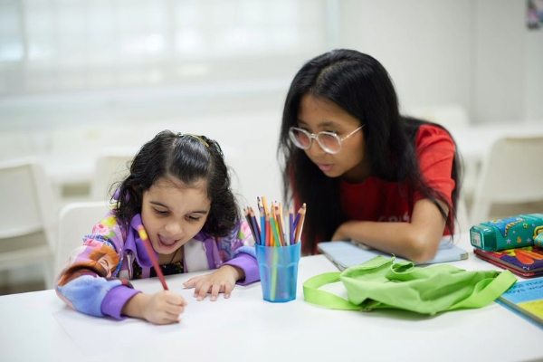 A volunteer engaging a child through a colouring activity.