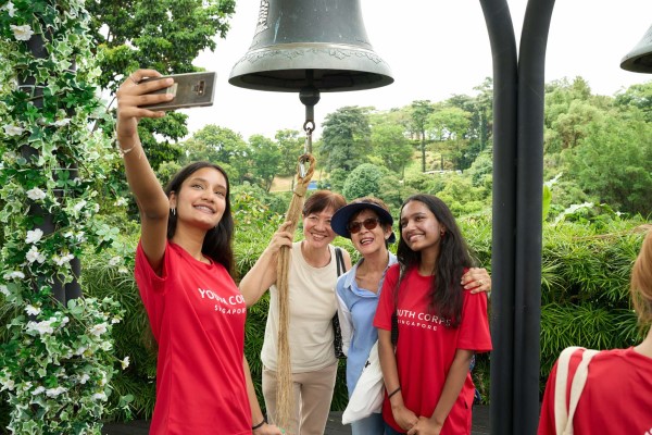 A group of volunteers and beneficiaries taking a photo together in the outdoors.
