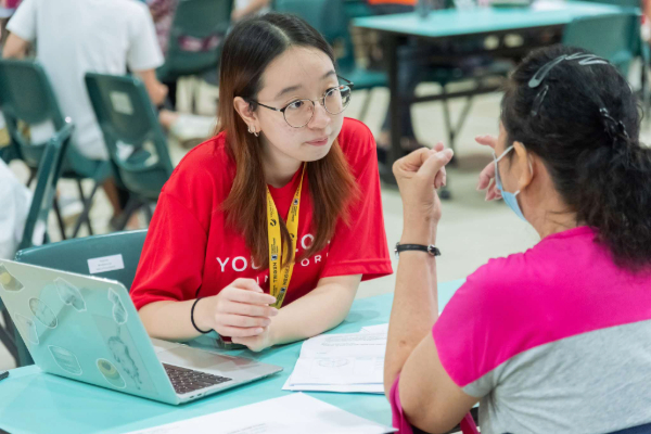 A volunteer interacting with a senior.