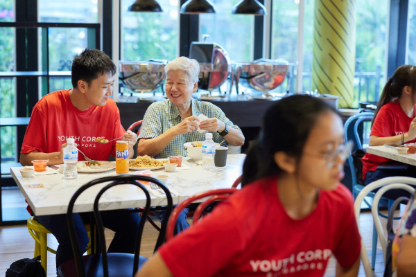 A volunteer and senior having a conversation over lunch.