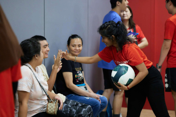 Volunteer giving a person with special needs a ‘high five’.